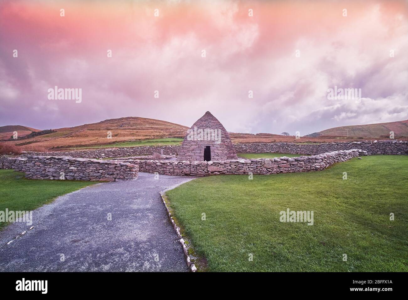 Tramonto a tarda sera con vista bella rosa del Gallarus Oratory tomba nella penisola di Dingle sulla Wild Atlantic Way County Kerry Irlanda Foto Stock