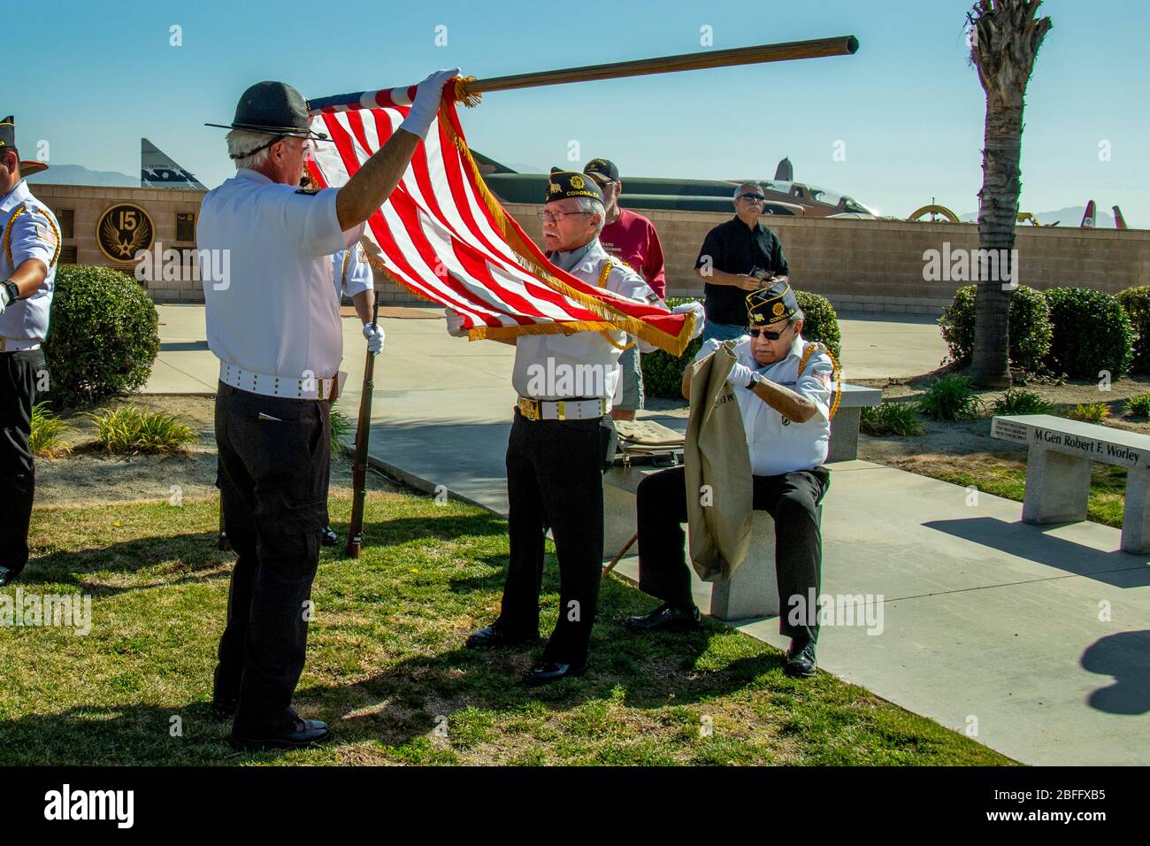 Una guardia d'onore della Legione americana srotola una bandiera degli Stati Uniti in preparazione ad una cerimonia patriottica a Riverside, CA. Foto Stock