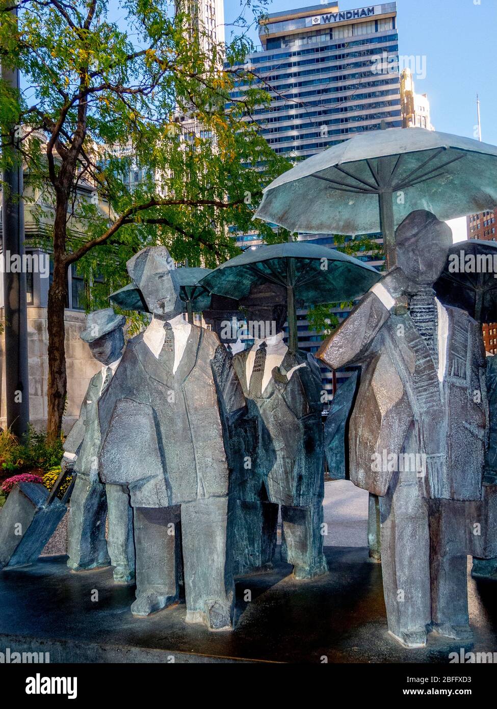 The Living World Series Gentlemen Statua dello scultore taiwanese Ju Ming questa opera d'arte è esposta in modo preminente sul Chicago ama Plaza. I signori fanno parte della "Living World Series" di Ju, con undici figure placcate in bronzo drappate in giacche da trincea e ombrelli. Bloccanti e minimalisti, le figure sono ridotte alle forme di base intenzionalmente per abbracciare le qualità spirituali interne all'interno del corpo umano. Foto Stock