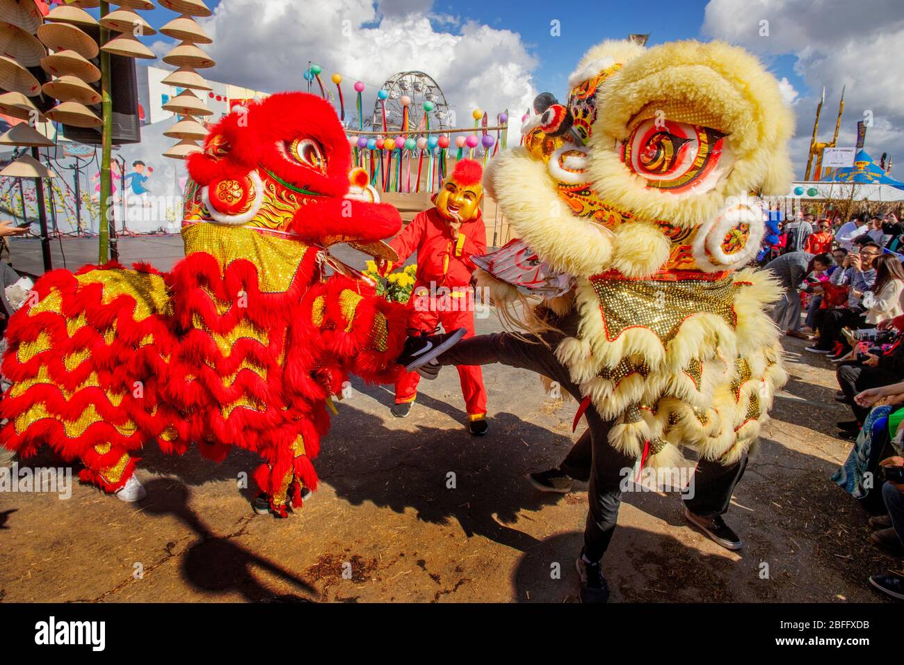 Draghi danzanti e un interprete mascherato celebrano il Capodanno Asiatico Lunar in un festival a Costa Mesa, California. Foto Stock