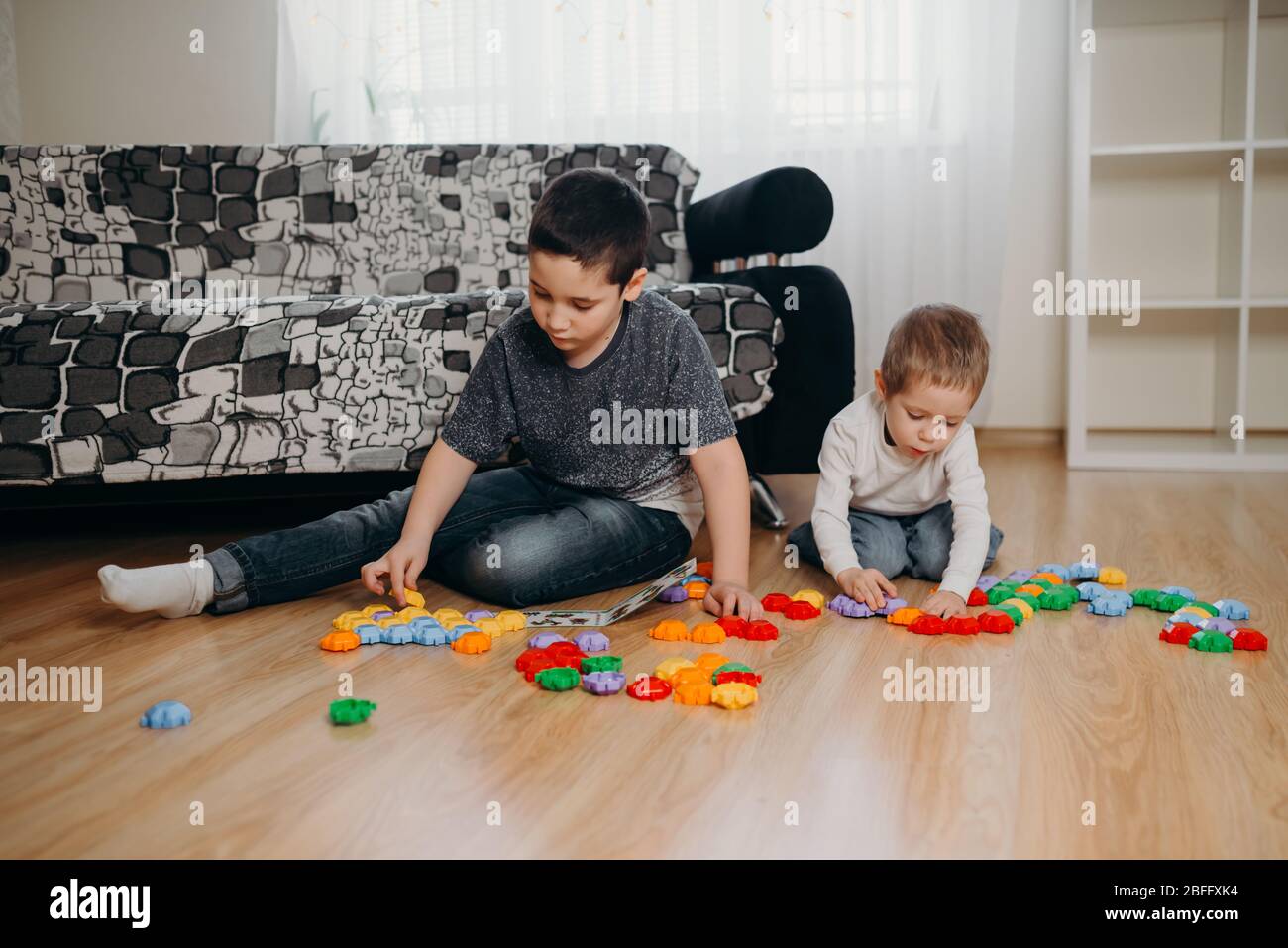 I bambini giocano a casa a giochi educativi. Quarantena. Weekend per famiglie Foto Stock