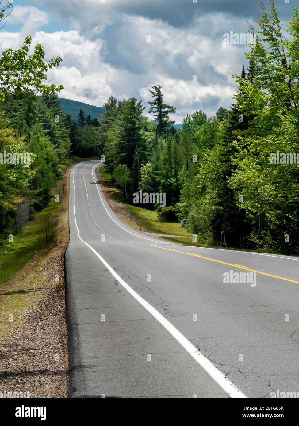 Le nuvole tempesta si raccolgono sulla Route 116, una strada a due corsie nella campagna del New Hampshire. Foto Stock