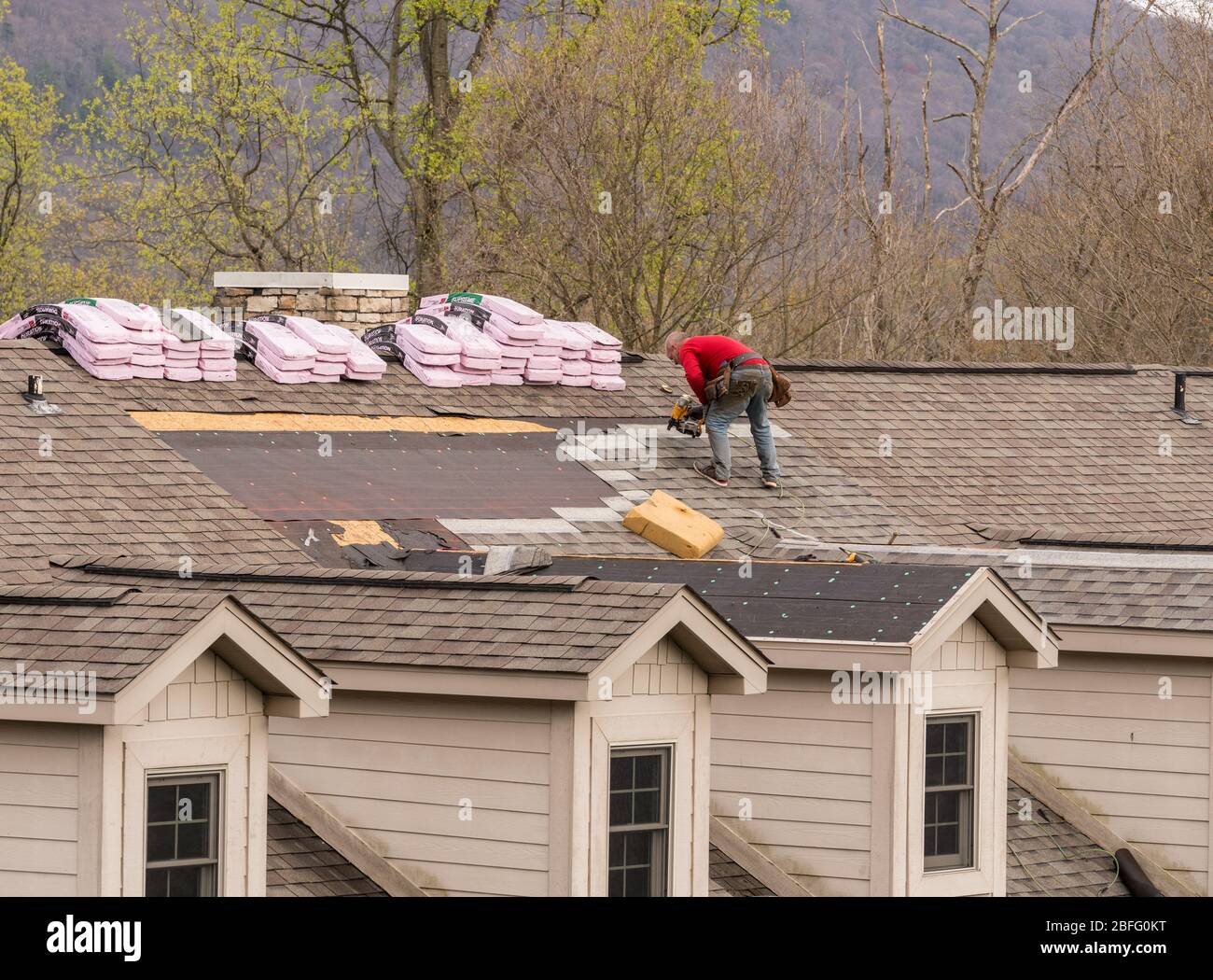 Morgantown, WV - 18 aprile 2020: I fornitori di tetti sostituiscono le vecchie assicelle su un tetto della casa Foto Stock