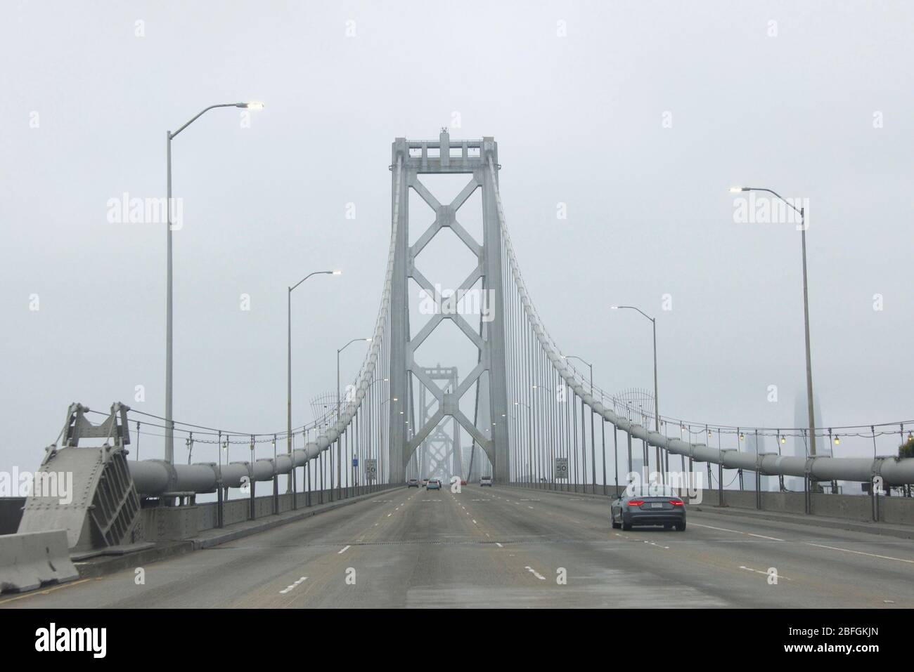 Guida POV attraverso il ponte superiore del Bay Bridge in San Francisco in una giornata molto nebbia, tipica della Bay Area. Foto Stock