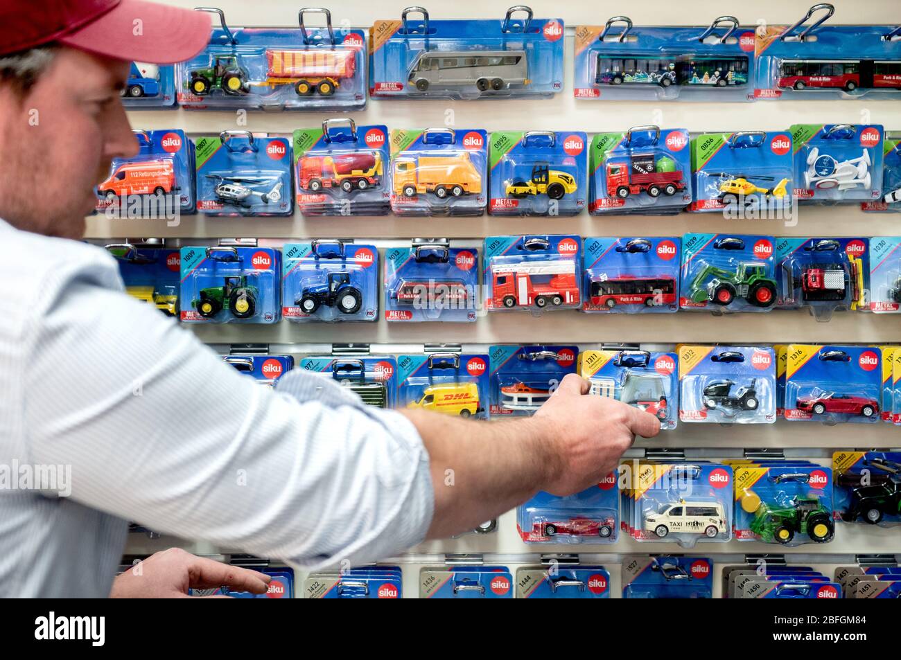 Peine, Germania. 17 Aprile 2020. Nils Willmann, direttore generale di un  negozio di giocattoli nel centro della città, mette le auto modello su uno  scaffale di vendita. Da lunedì in poi, i