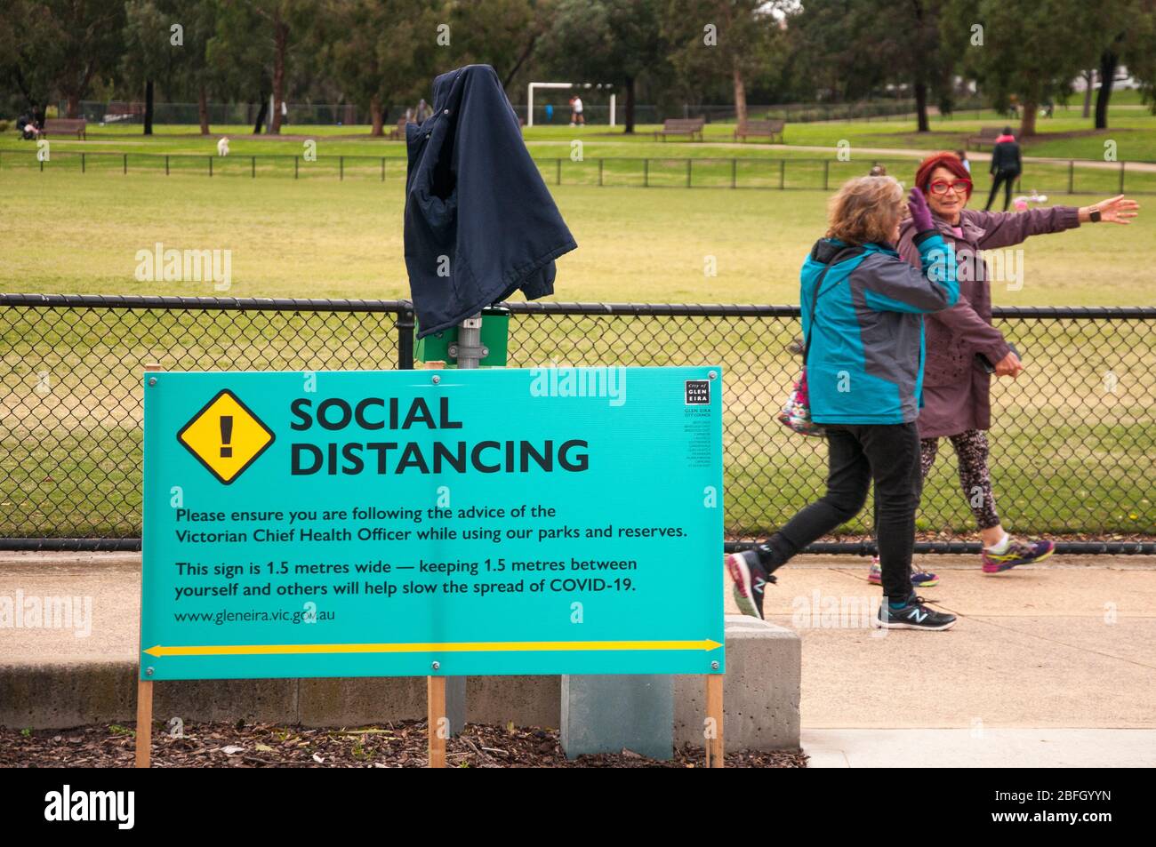 L'avviso del governo locale in un parco suburbano promuove le distanze sociali durante la pandemia COVID-19, Melbourne, Australia Foto Stock