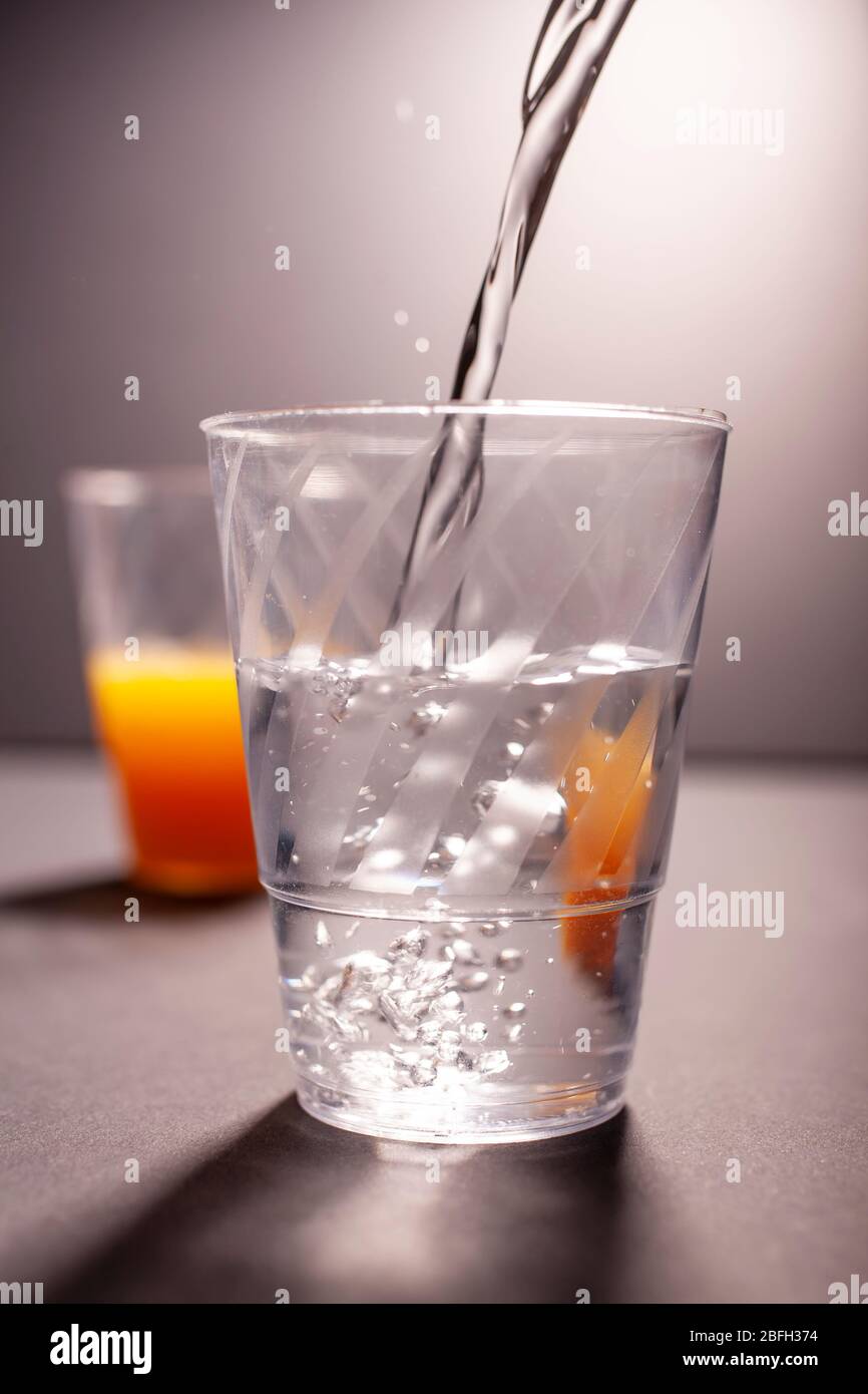 Versare acqua nel bicchiere Foto Stock