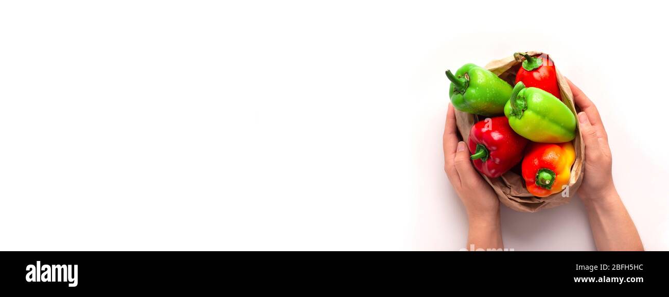 Mani contadine che tengono paprika colorata in sacchetto di carta eco-friendly Foto Stock
