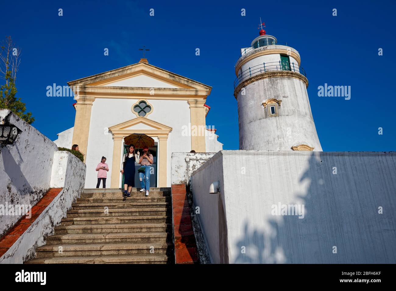 I turisti camminano lungo le scale presso la Fortezza di Guia, il forte militare coloniale del XVII secolo, la cappella e il complesso faro a Macao, Cina. Foto Stock