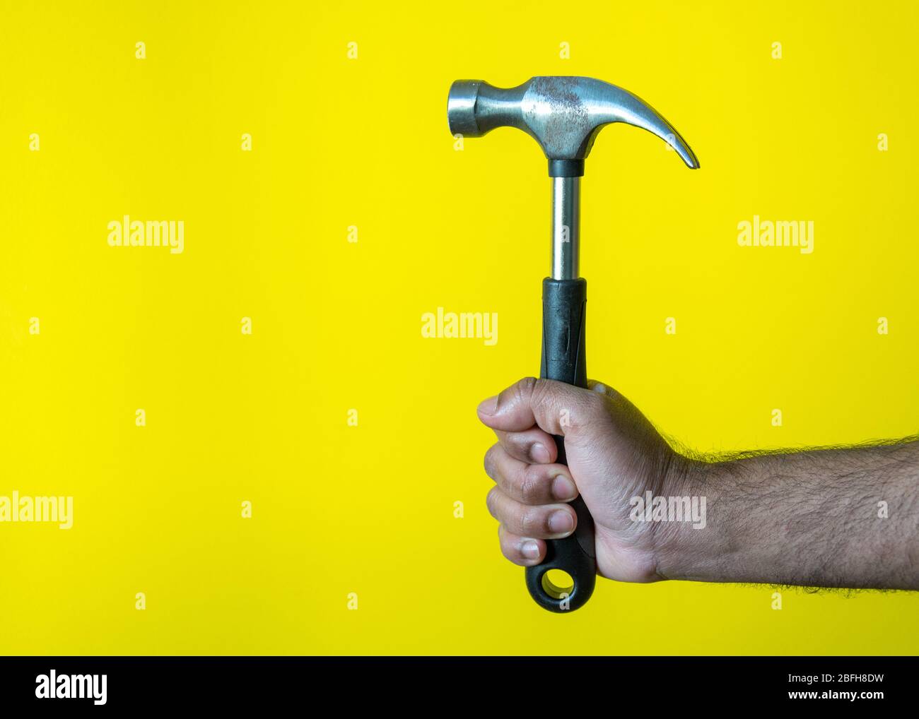 Modello maschio martello di supporto per fissare a casa come falegname con sfondo giallo, Svezia Foto Stock