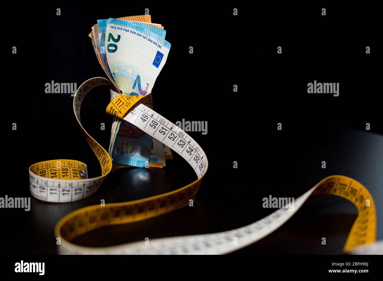 Banconote inasprite dal provvedimento a nastro su sfondo nero per il concetto di crisi finanziaria Foto Stock Banconote inasprite dal provvedimento a nastro su sfondo nero per il concetto di crisi finanziaria Foto Stock