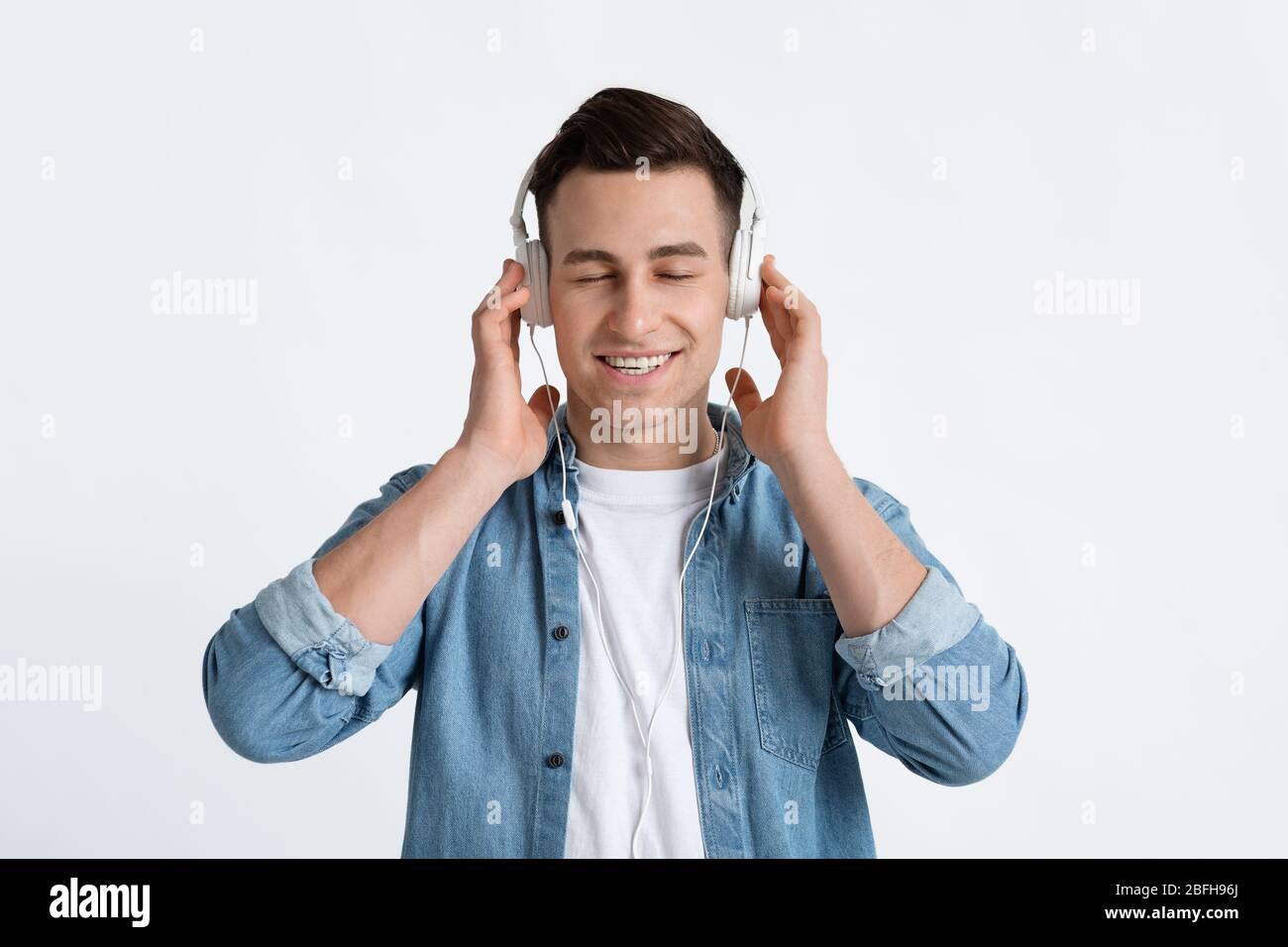 Uomo moderno con cuffie con occhi chiusi Foto Stock