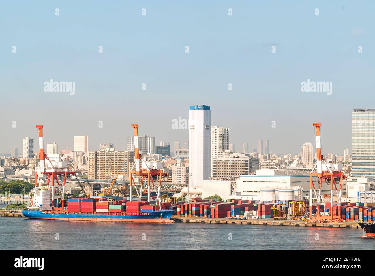 Grandi contenitori di carico barca con merci cargo pila presso il molo docks porto in attesa del mare internazionale trasporto merci di importazione e di esportazione nel Toky Foto Stock