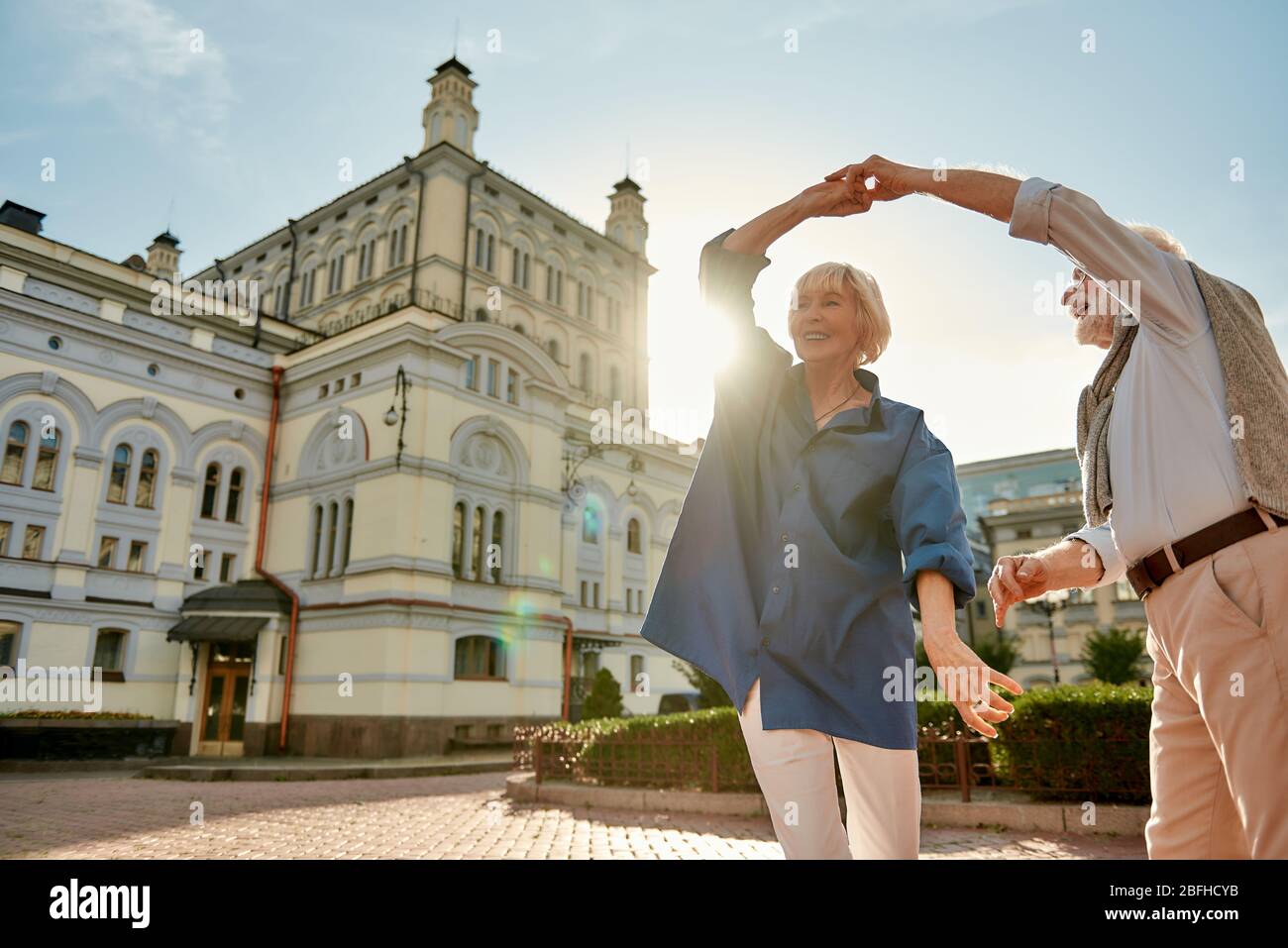 È sempre divertente passare il tempo con te. Bella e felice coppia senior ballare insieme all'aperto in una giornata di sole. Divertimento. Concetto di amore Foto Stock