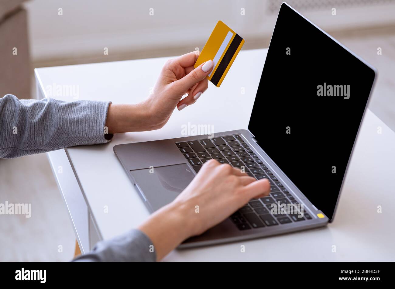Ordina l'acquisto online. Donna con laptop e carta di credito. Foto Stock