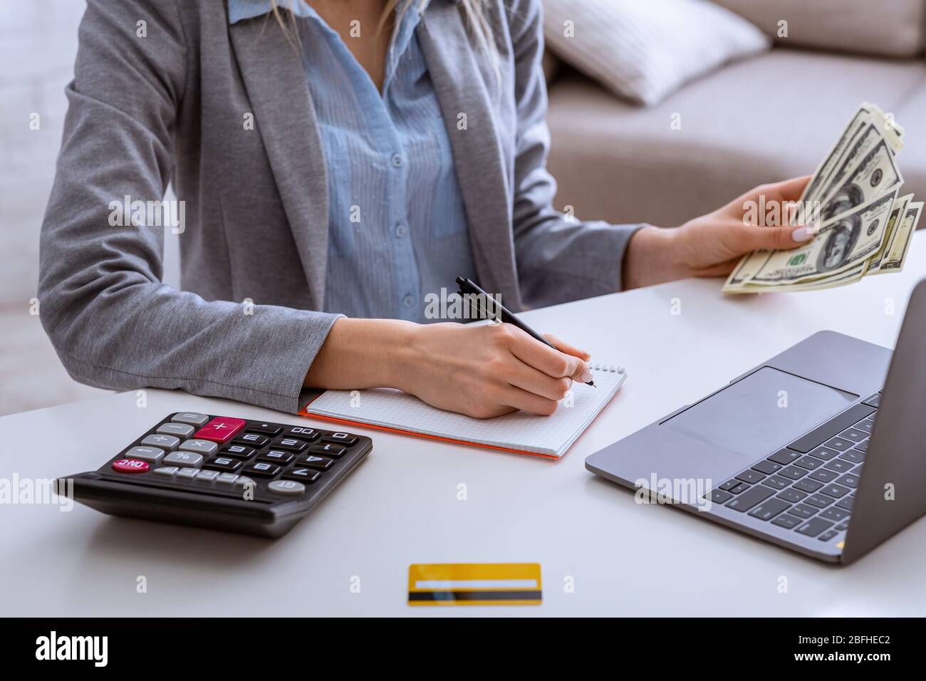 Piano finanziario durante la crisi. Donna fa lista in blocco note Foto Stock