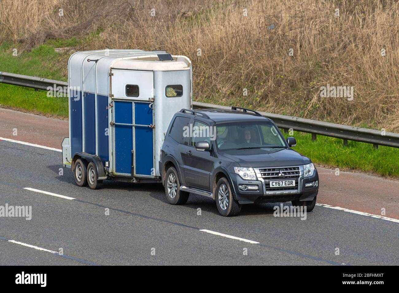 2017 grigio Mitsubishi Shogun SG2 DI-D SWB Auto trainante Cavallo; trasporto di animali che viaggia sulla M6 autostrada, Lancashire, Regno Unito Foto Stock