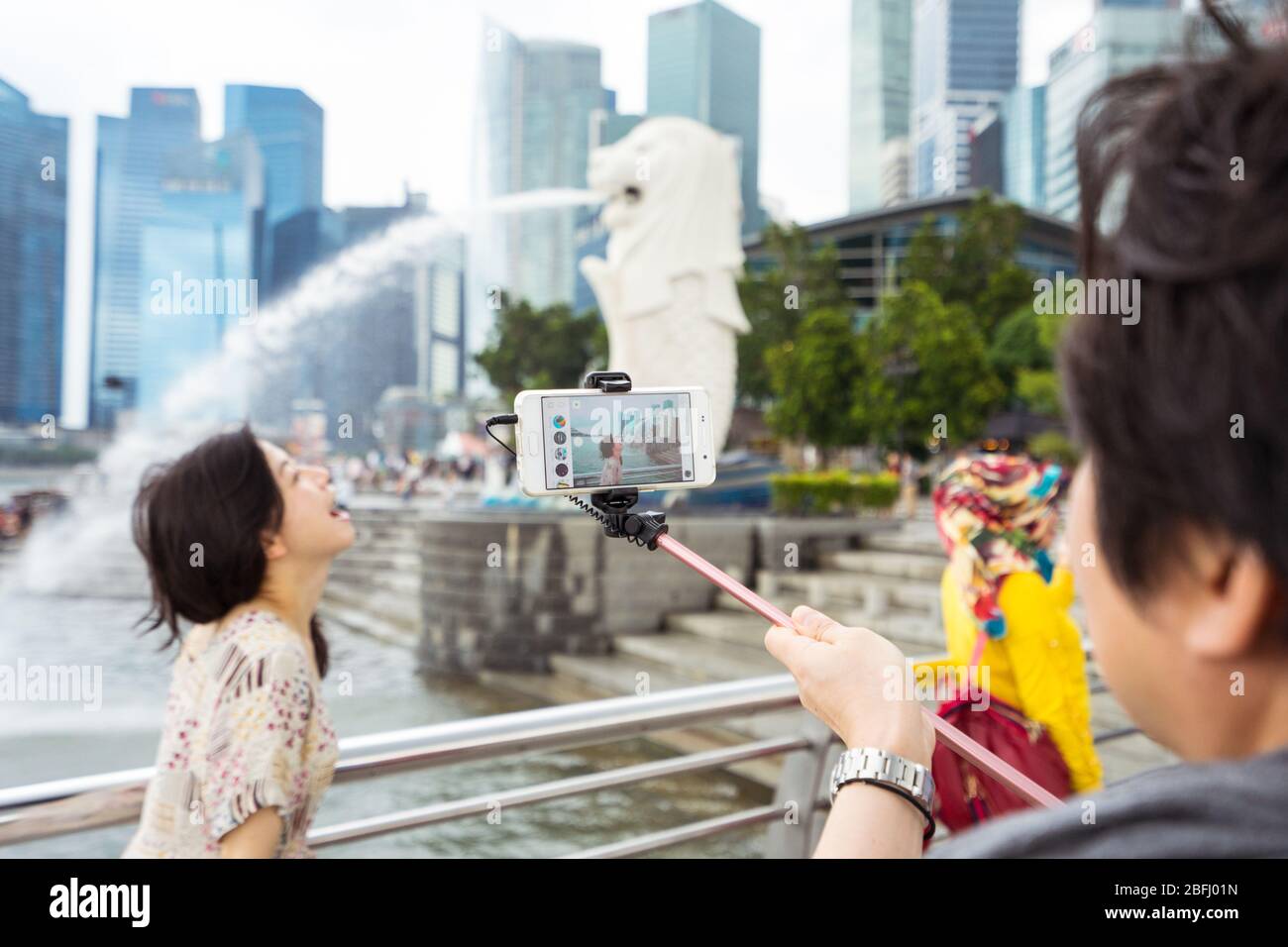 Singapore / Singapore - 15 febbraio 2019: Turisti cinesi asiatici che scattano foto di fronte alla scultura del Leone chiamata Merlion Foto Stock