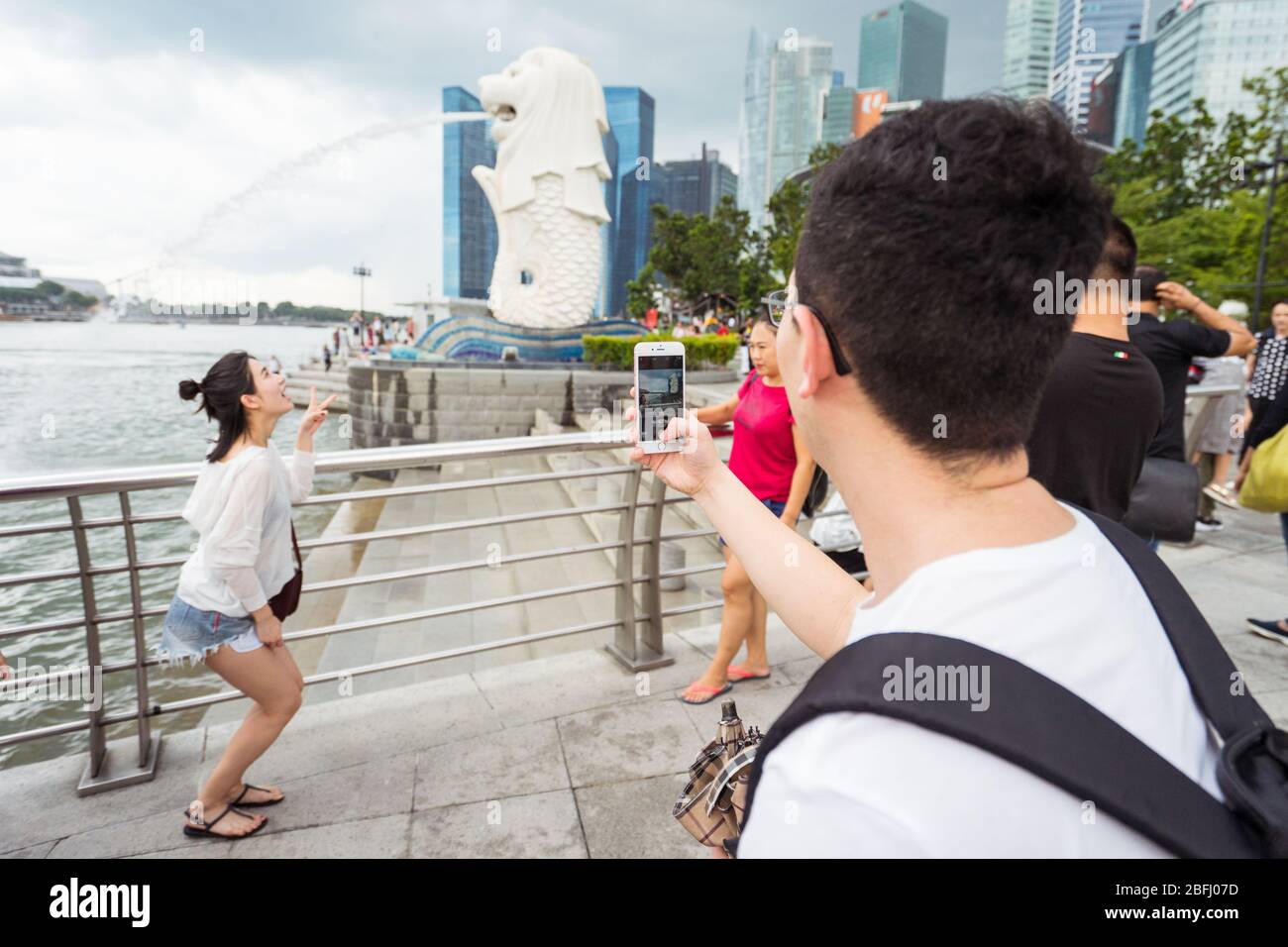 Singapore / Singapore - 15 febbraio 2019: Turisti cinesi asiatici che scattano foto di fronte alla scultura del Leone chiamata Merlion Foto Stock