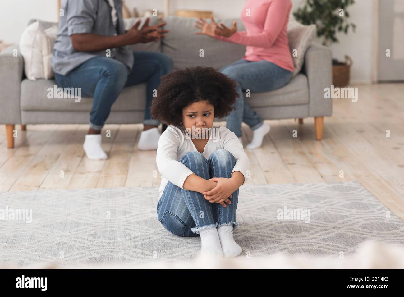 Innocente piccola ragazza afro-americana che soffre di conflitti familiari Foto Stock