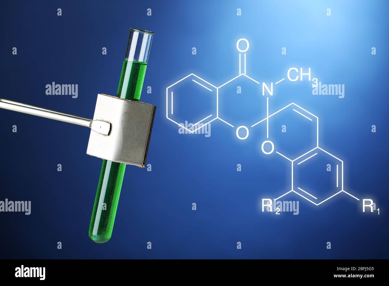 Provetta da laboratorio riempita di liquido colorato, tenuta in un morsetto speciale durante l'esperimento scientifico Foto Stock