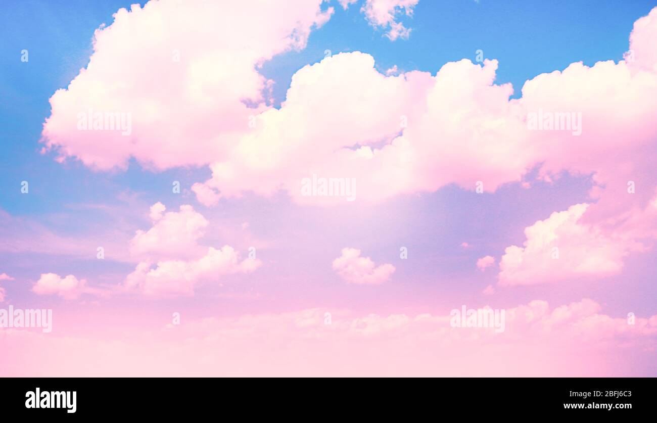 Blu cielo sfondo con nuvole rosa Foto stock - Alamy