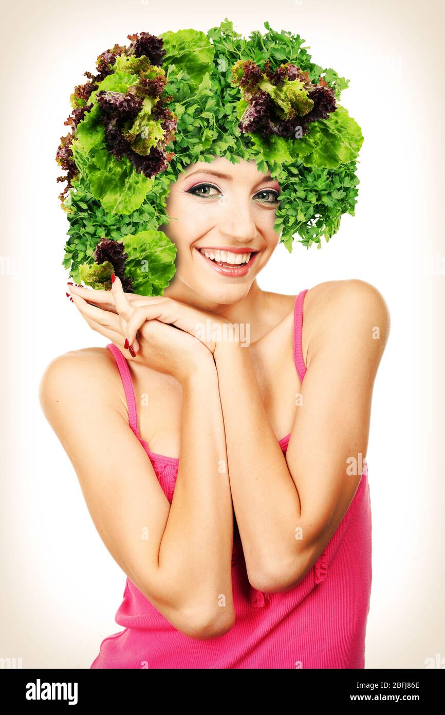 Bella giovane donna con parrucca vegetale isolato su bianco Foto Stock