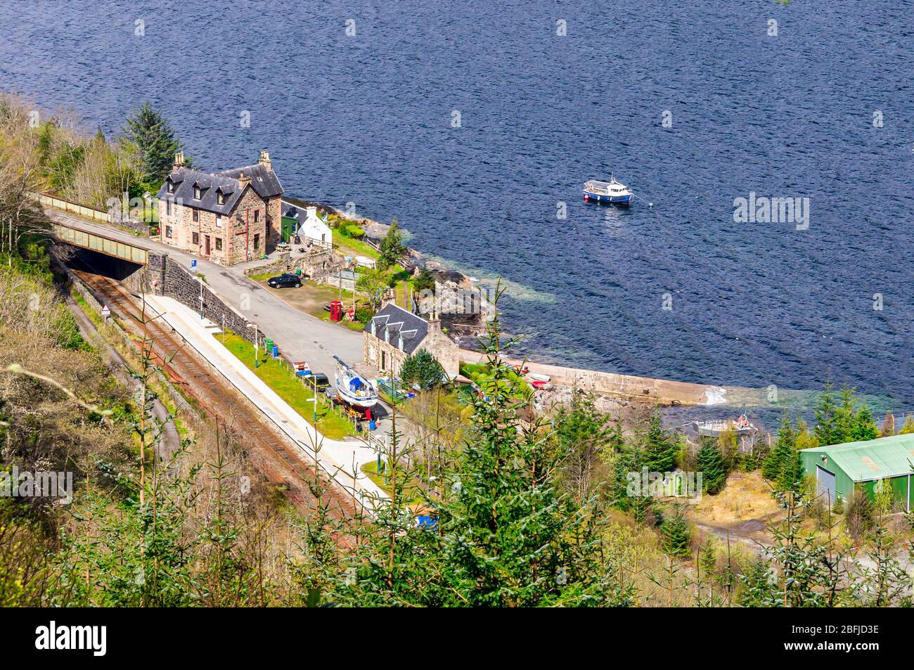 Vista verso il basso del villaggio di Stromeferry con la stazione ferroviaria di Loch Carron in Highland Scotland UK dalla A890 sopra Foto Stock