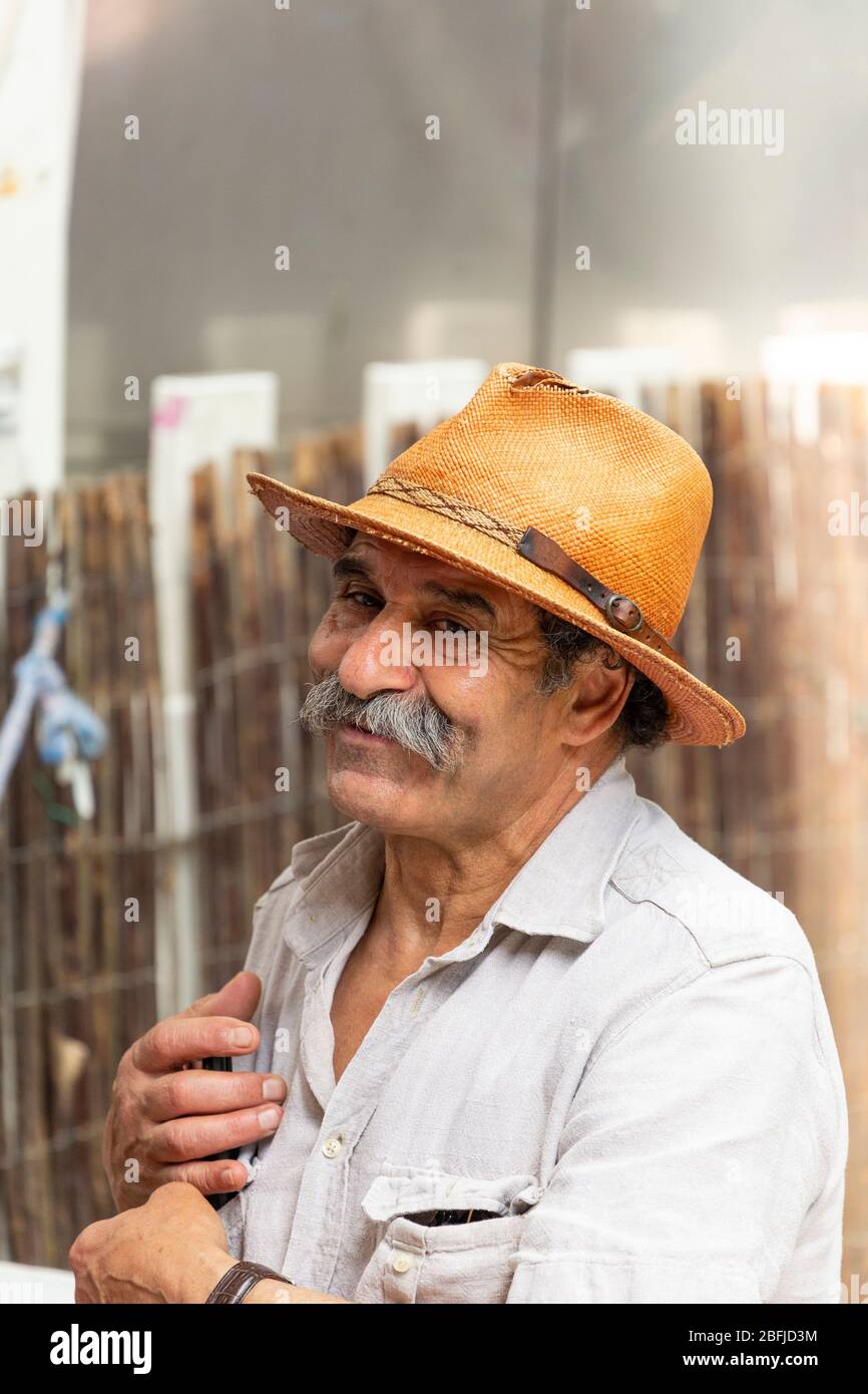 Ritratto di un uomo sorridente con un cappello e baffi al mercato degli artisti di Montmartre, Parigi Foto Stock