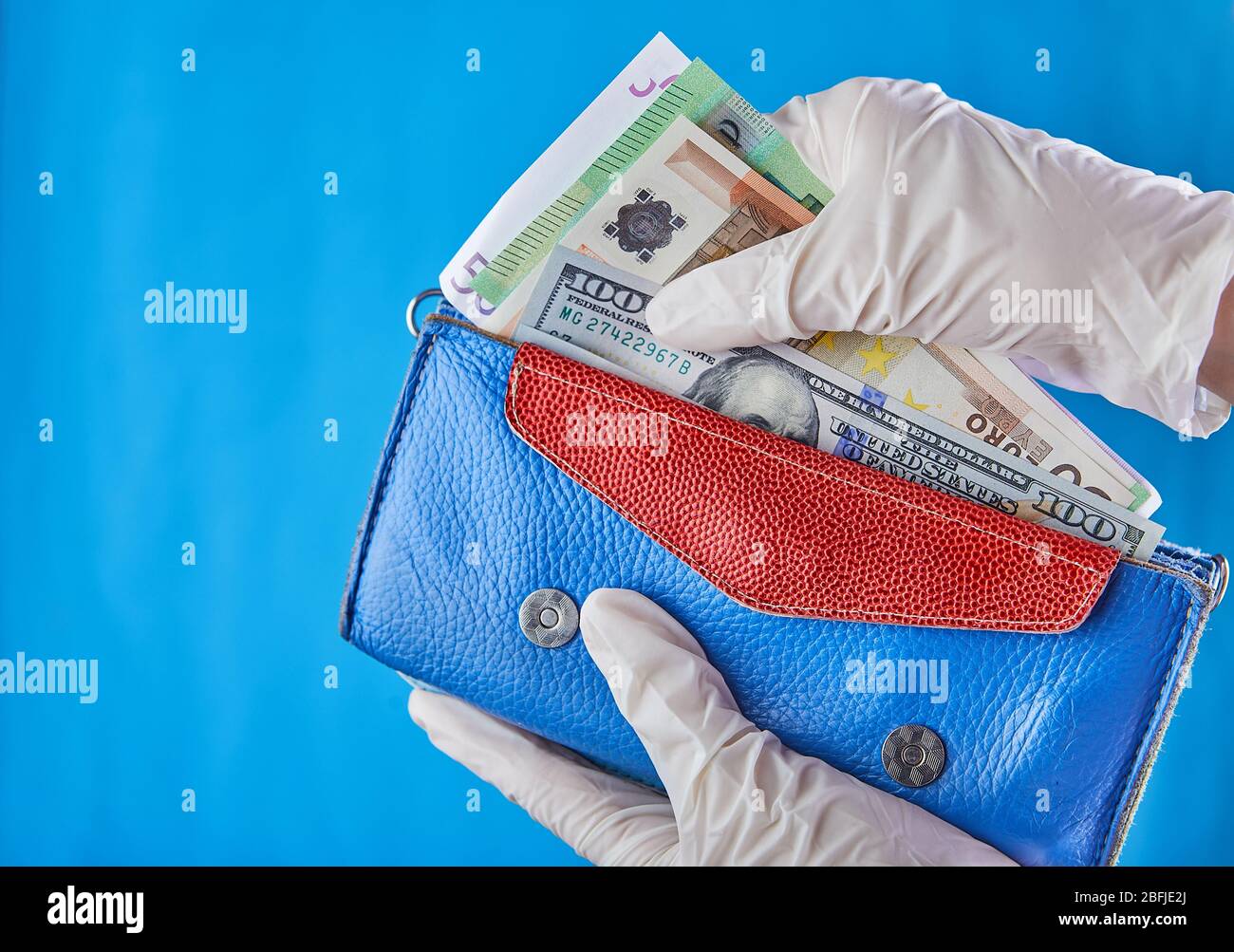 Una donna che prende i soldi dal suo portafoglio indossando guanti di gomma  per prevenire la diffusione di batteri o virus-shopping durante la pandemia  coronavirus Foto stock - Alamy