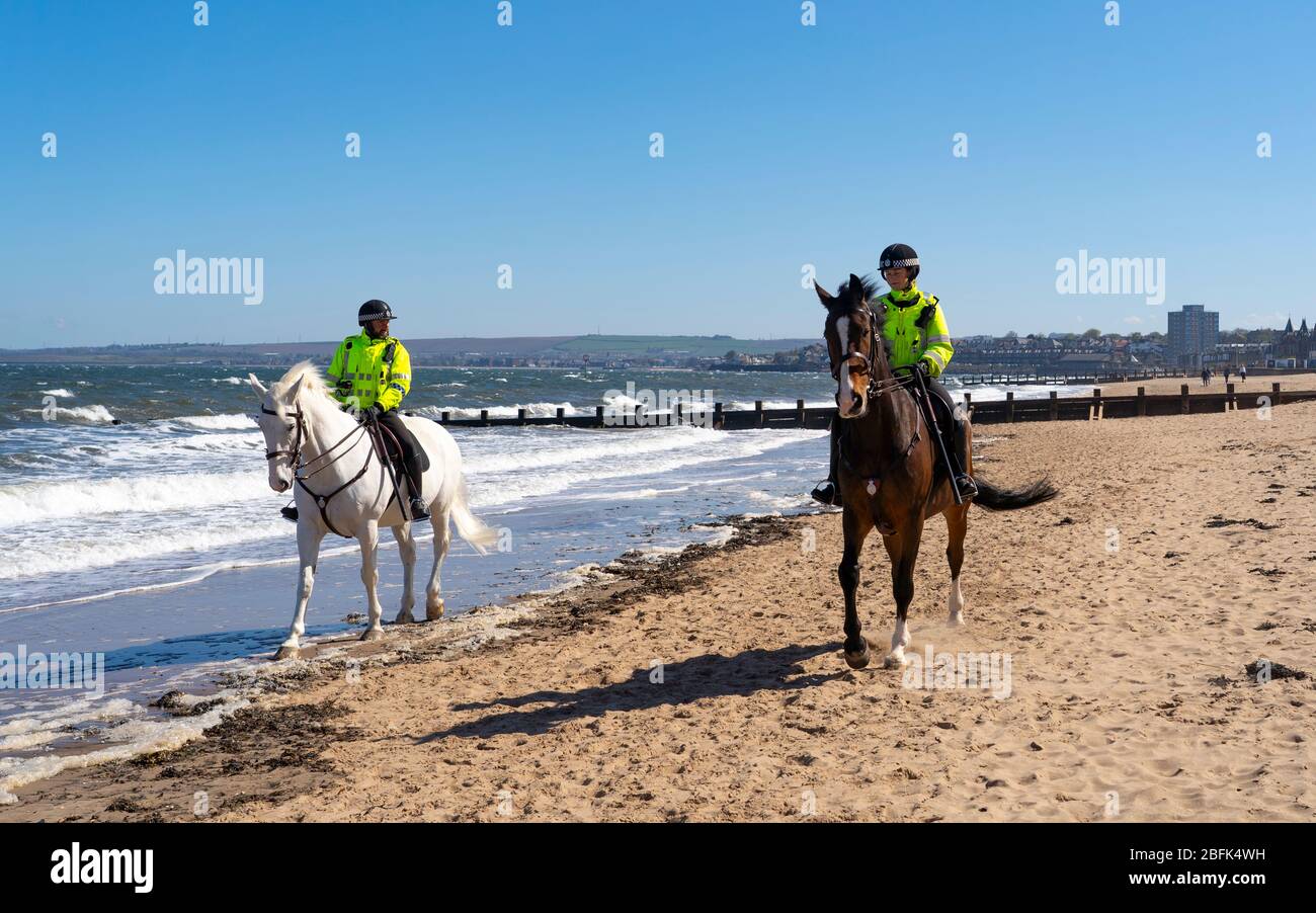 Portobello, Scozia, Regno Unito. 19 aprile 2020. Cavalli di polizia montati Logie e Edimburgo - in bianco, pattuglia la passeggiata e la spiaggia a Portobello la domenica pomeriggio. Iain Masterton/Alamy Live News Foto Stock