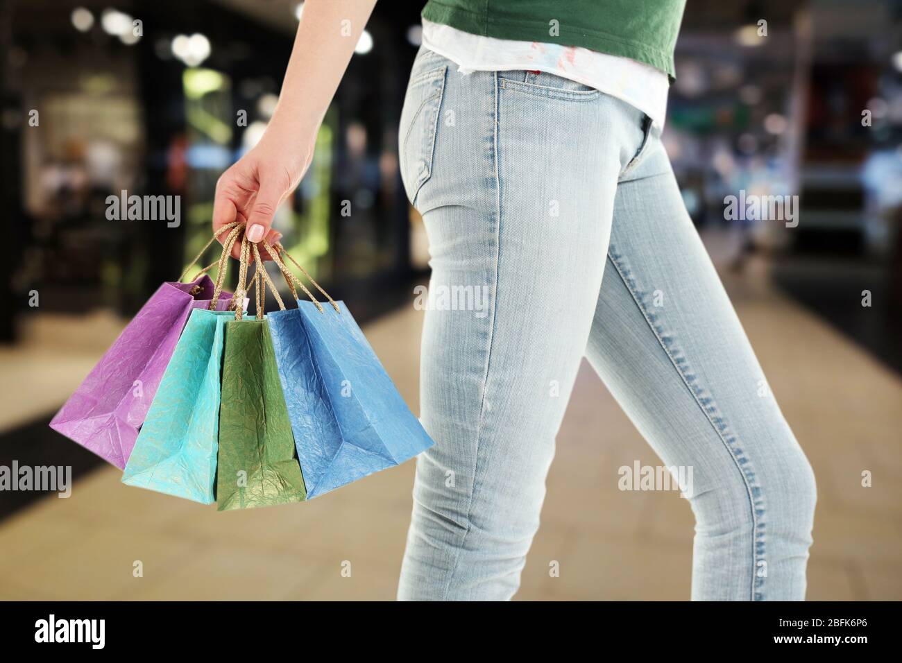 Mano femminile con borse di carta per lo shopping sul mercato Foto Stock