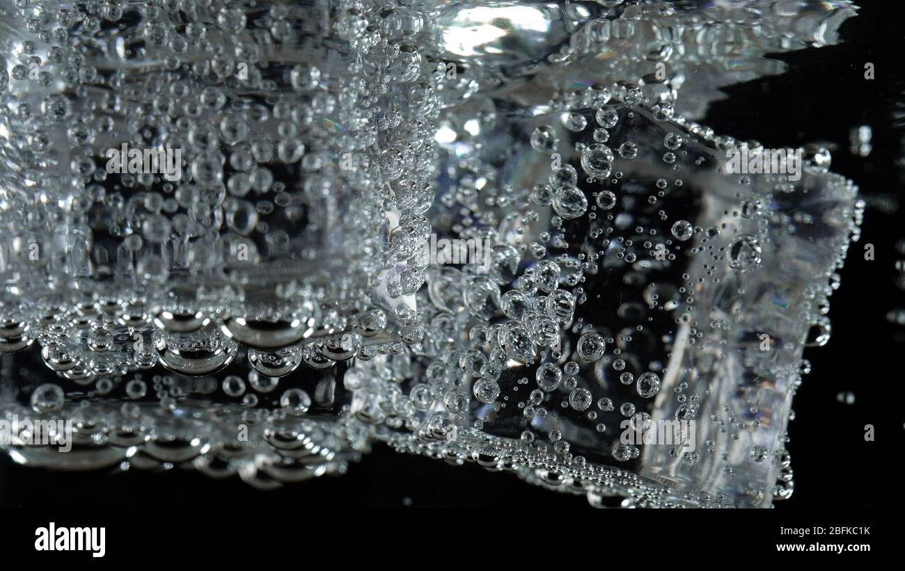 cubo di ghiaccio in acqua frizzante con bolla di soda Foto Stock