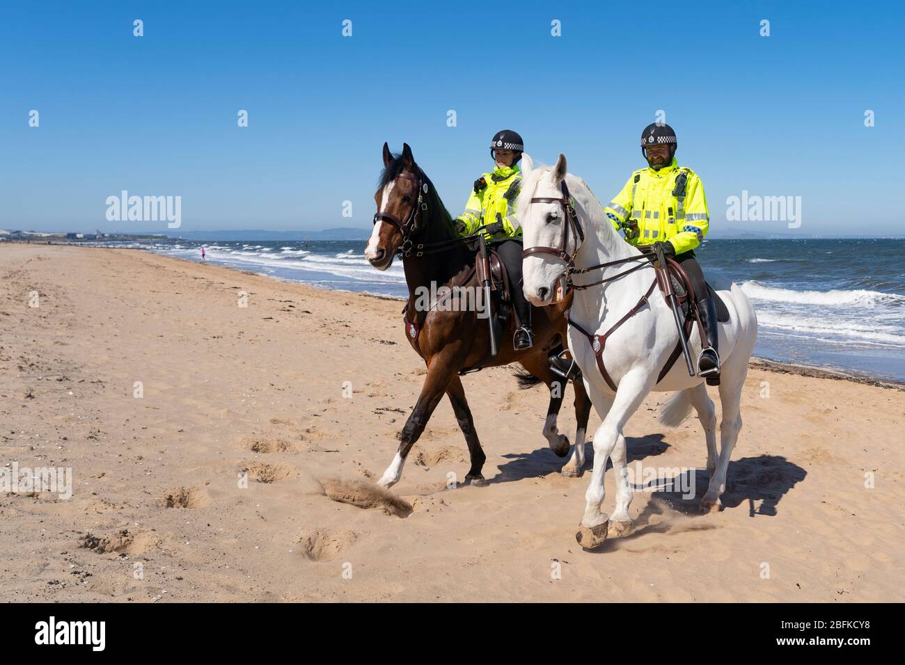 Portobello, Scozia, Regno Unito. 19 aprile 2020. Cavalli di polizia montati Logie e Edimburgo - in bianco, pattugliare la passeggiata e la spiaggia a Portobello la domenica pomeriggio. Iain Masterton/Alamy Live News Foto Stock