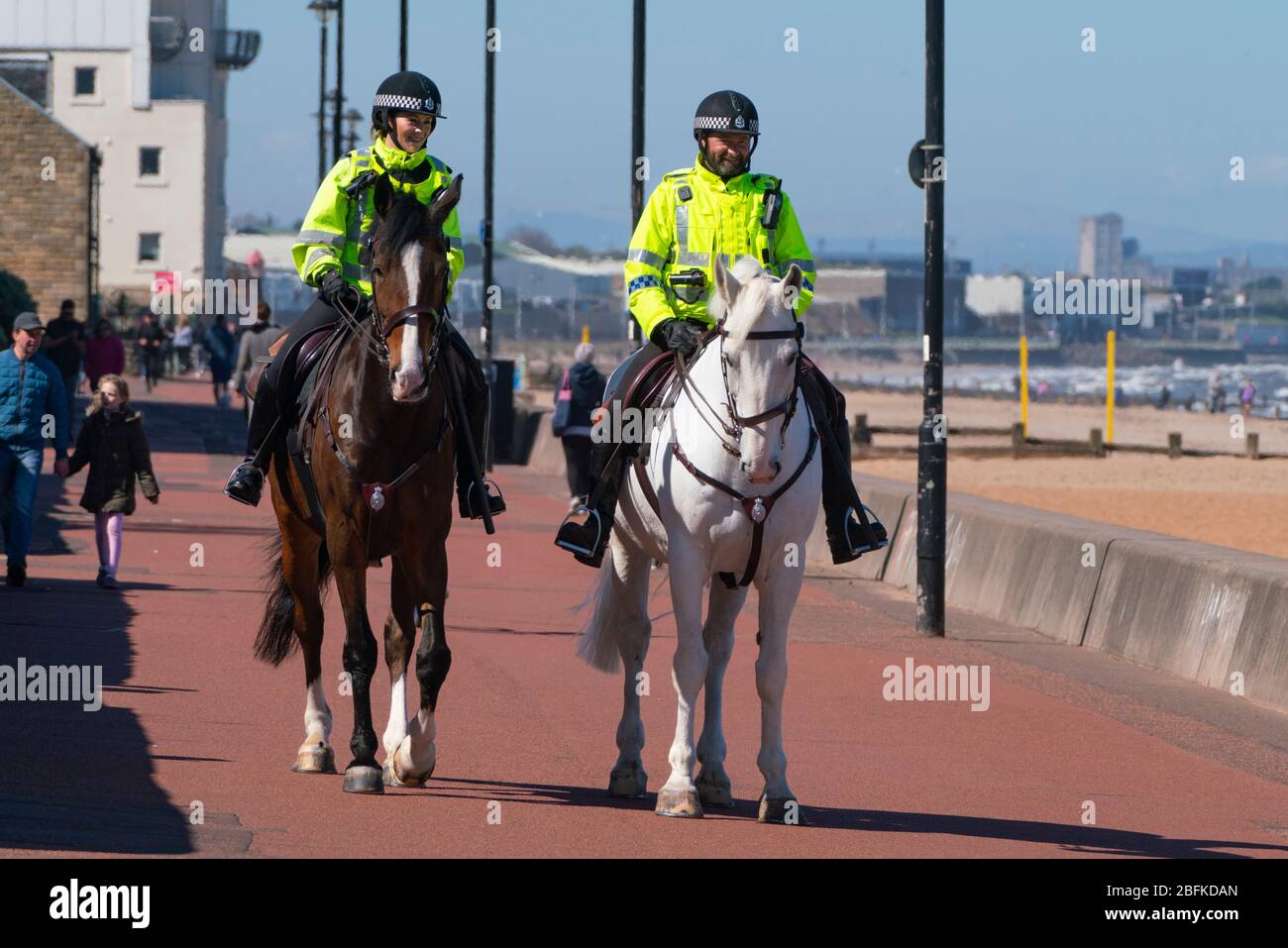 Portobello, Scozia, Regno Unito. 19 aprile 2020. Cavalli di polizia montati Logie e Edimburgo - in bianco, pattugliare la passeggiata e la spiaggia a Portobello la domenica pomeriggio. Iain Masterton/Alamy Live News Foto Stock