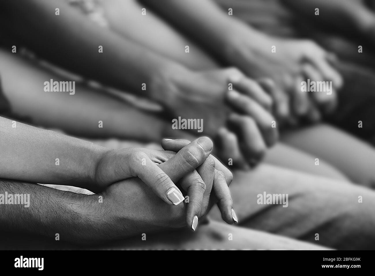 Giovani che tengono le mani in primo piano. Stilizzazione in bianco e nero Foto Stock