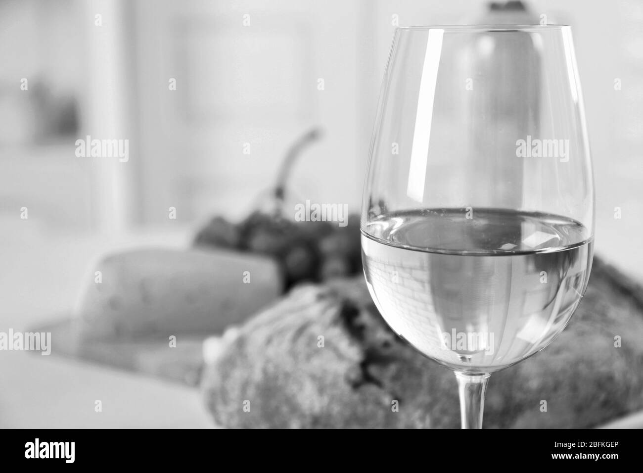 Ancora vita di vino, uva, formaggio e pane, stilizzazione retrò in bianco e nero Foto Stock