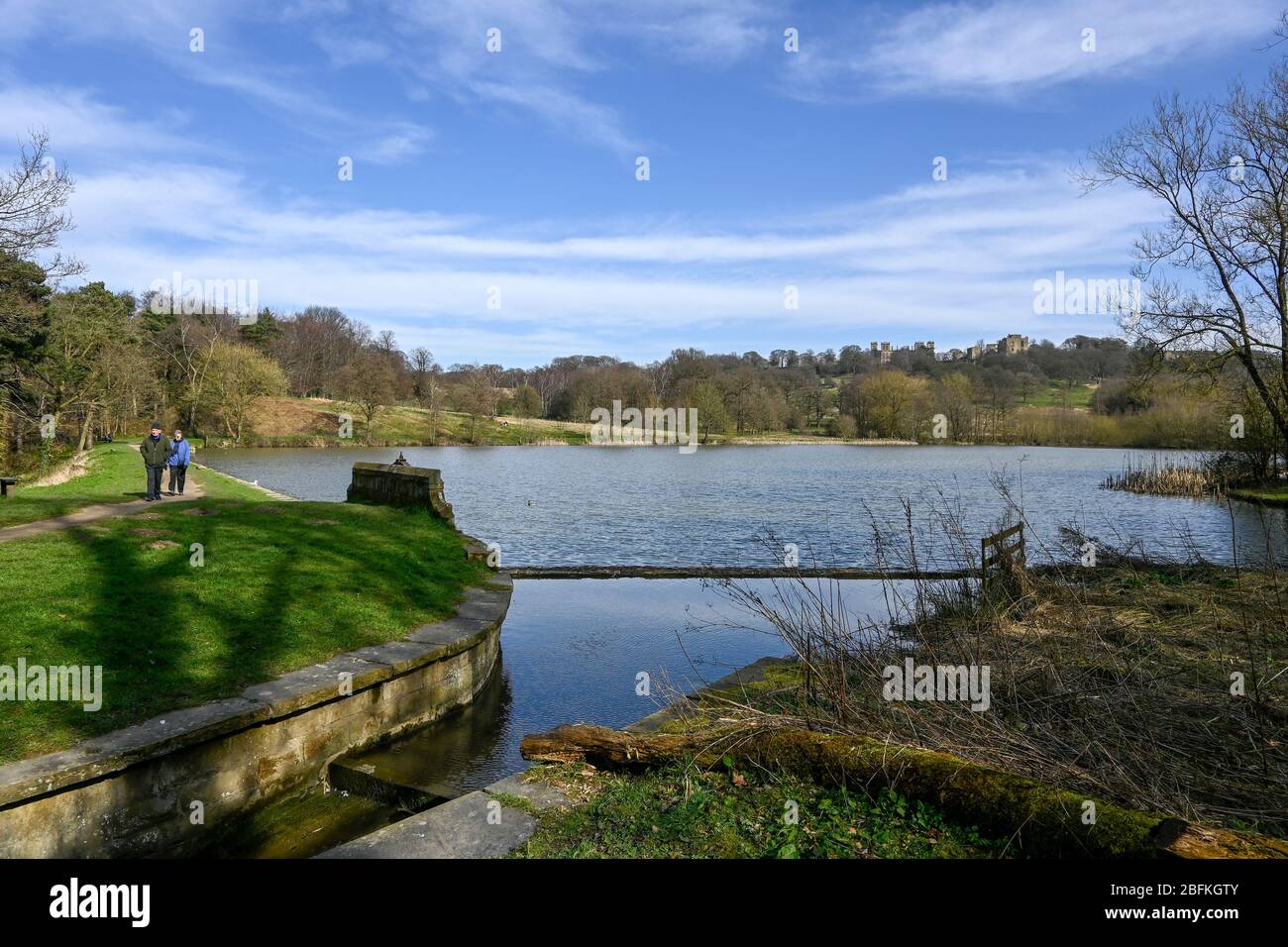 Coppia fuori a piedi vicino al lago a Hardwick Hall Derbyshire Inghilterra Foto Stock