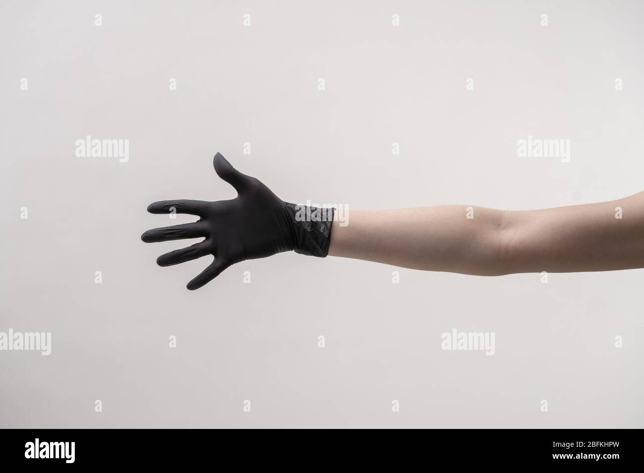 Mani in guanti in silicone nero su fondo chiaro. Foto Stock