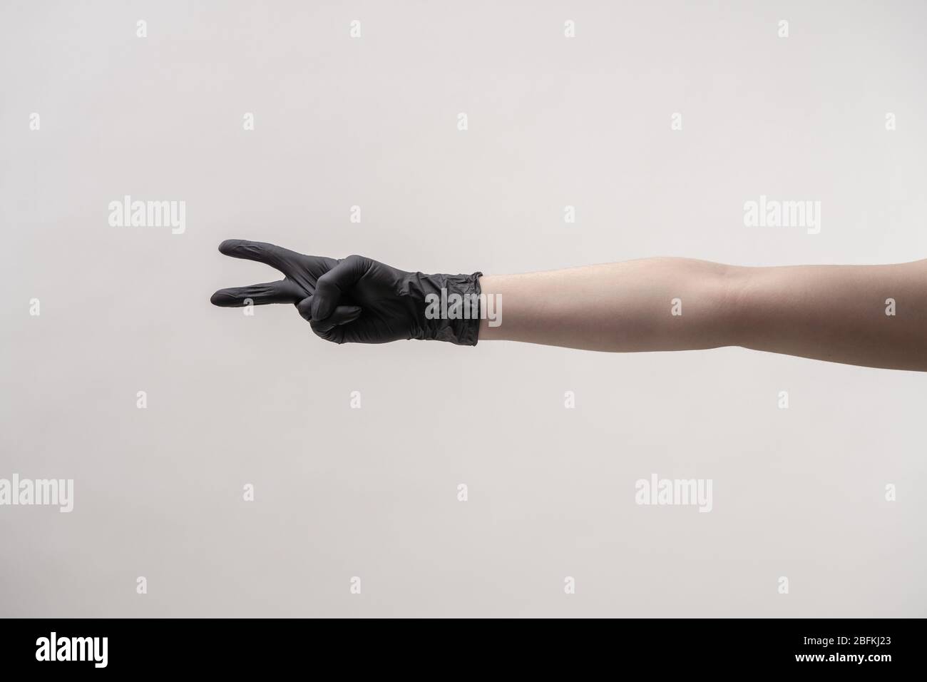 Mani in guanti in silicone nero su fondo chiaro. Foto Stock