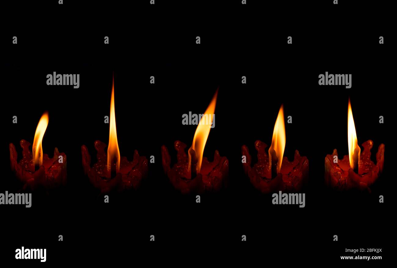 5 luce di candela di fiamma che brucia ardentemente su sfondo nero Foto Stock
