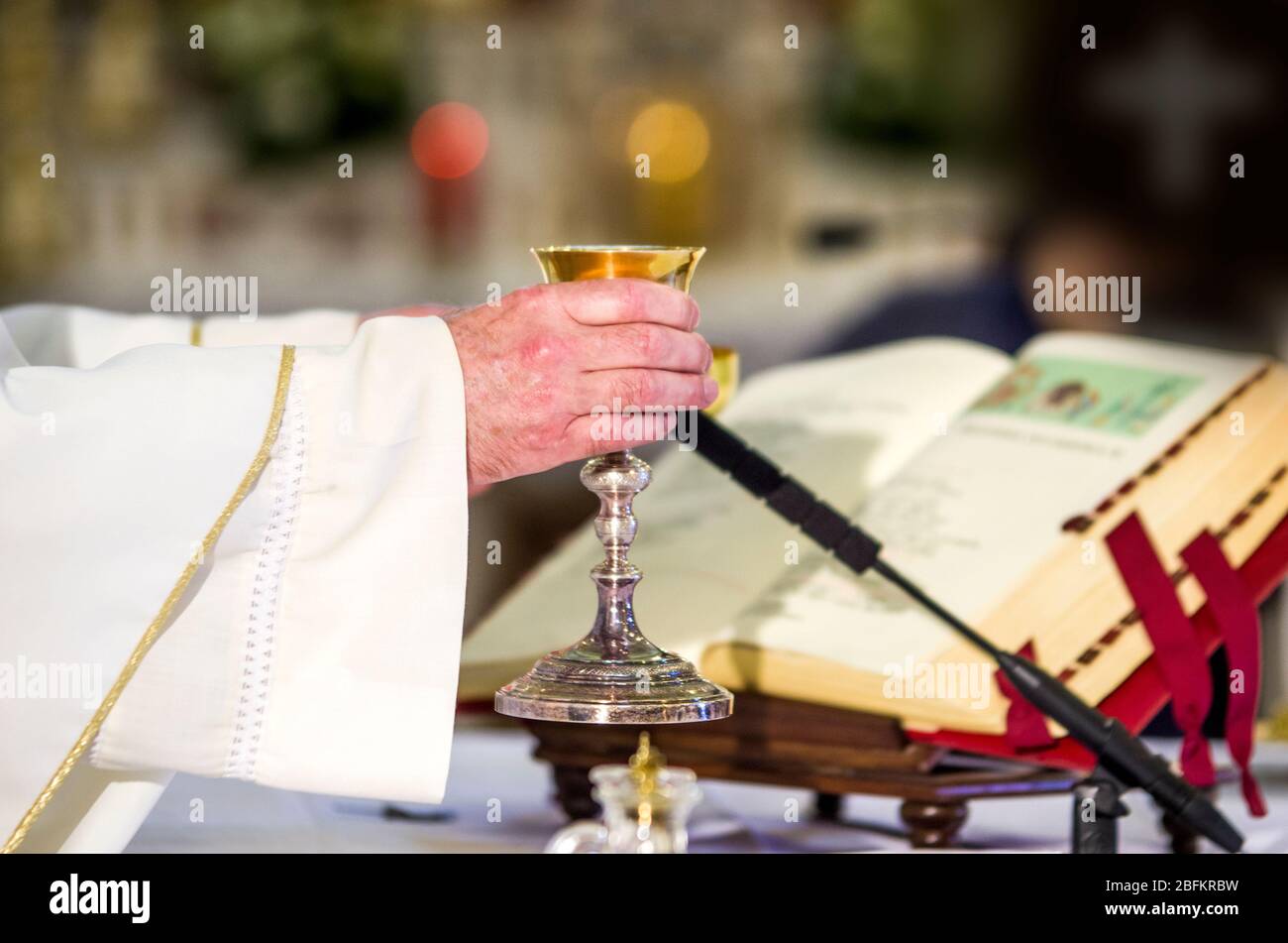 Calice con vino, consacrato nel sangue di Cristo risorto, pronto alla comunione dei fedeli durante la messa Foto Stock