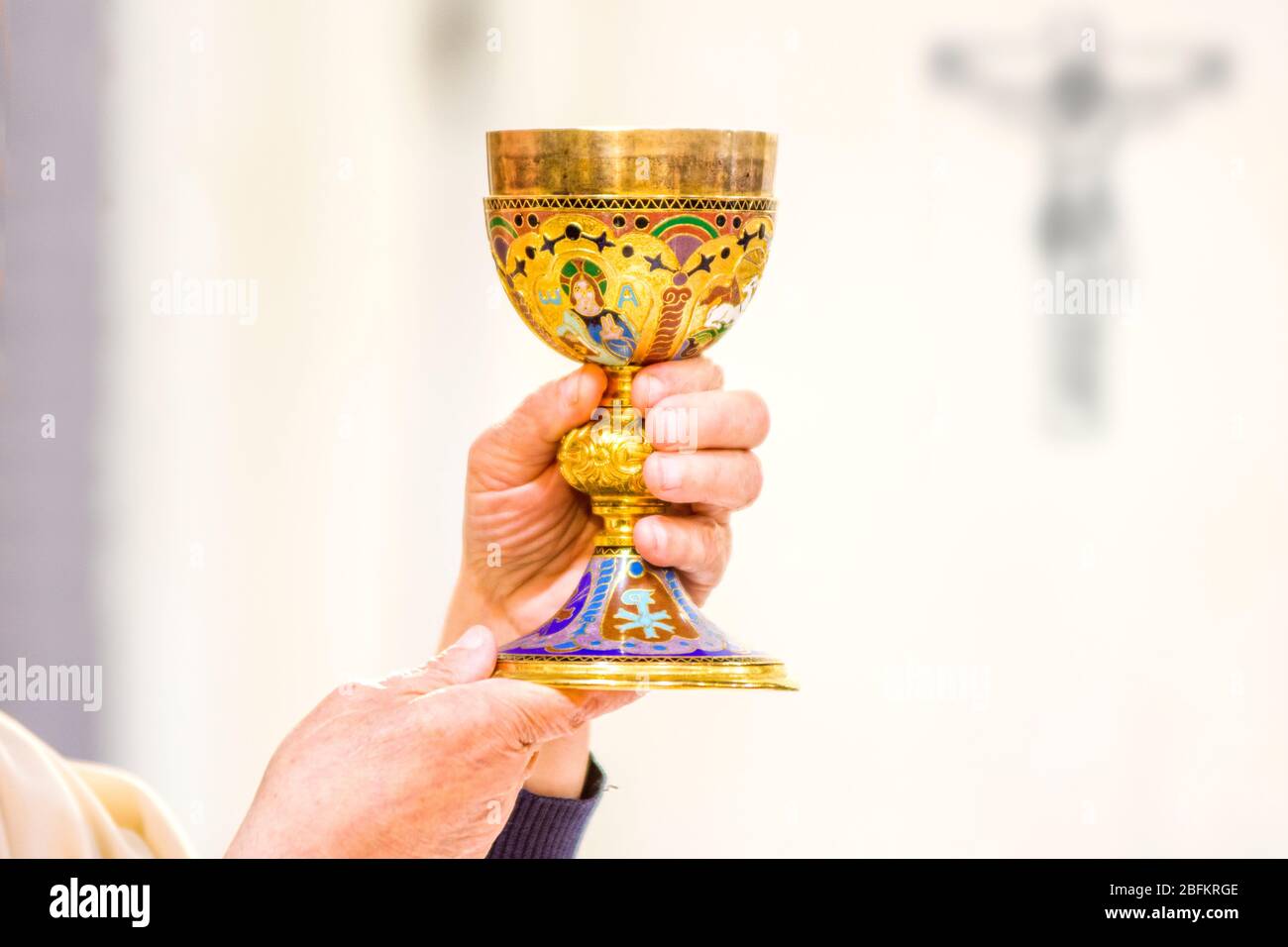 Calice con vino, consacrato nel sangue di Cristo risorto, pronto alla comunione dei fedeli durante la messa Foto Stock