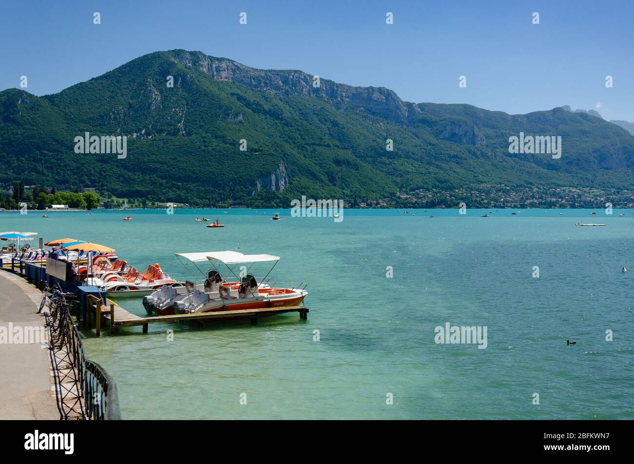 Barche disponibili in affitto ancorate sulle rive del Lago di Annecy in Francia Foto Stock