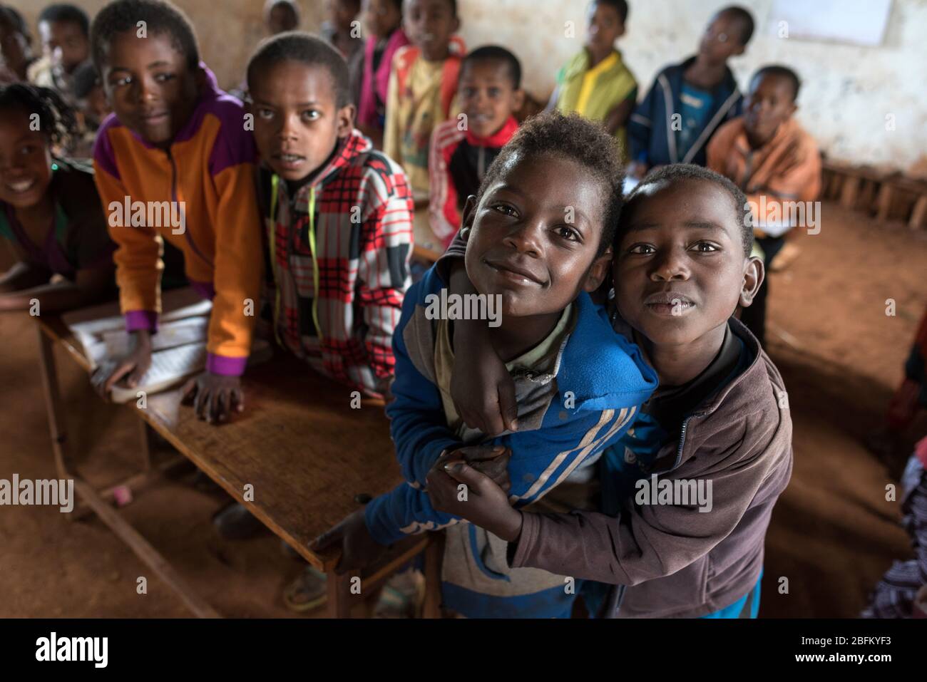 I bambini della scuola salutano i visitatori nella loro casa di scuola a una stanza a terra a Dorze, Etiopia, Africa. Foto Stock