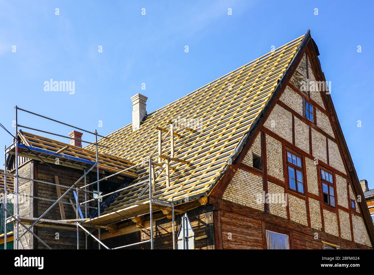 riparazione delle strutture del tetto di una storica casa in legno e sostituzione di piastrelle in argilla Foto Stock