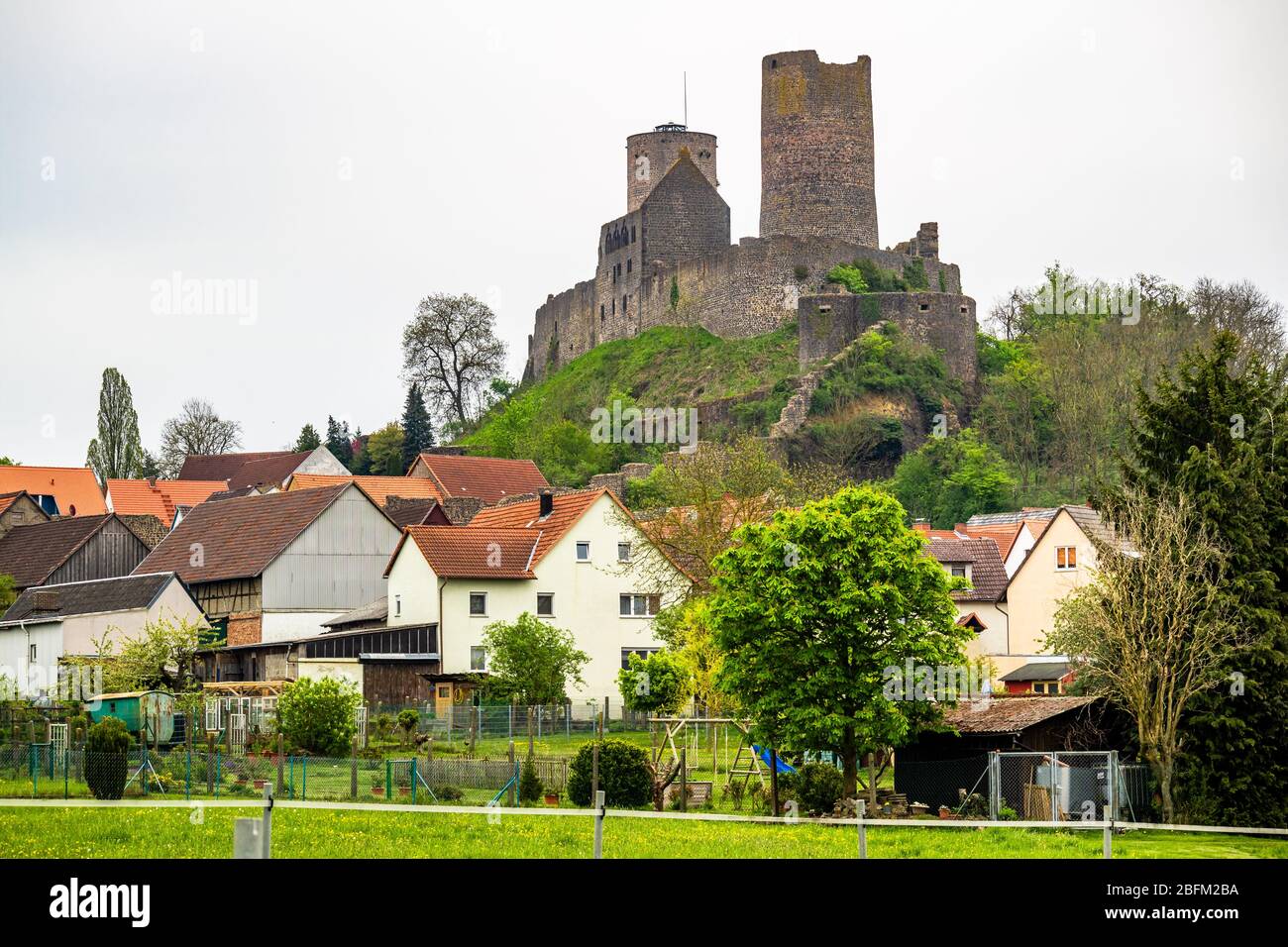 Vista della città Münzenberg con il castello di Münzenberg, un castello in rovina di collina dell'Alto Medioevo, il quartiere di Wetteraukreis, Hesse, Germania Foto Stock