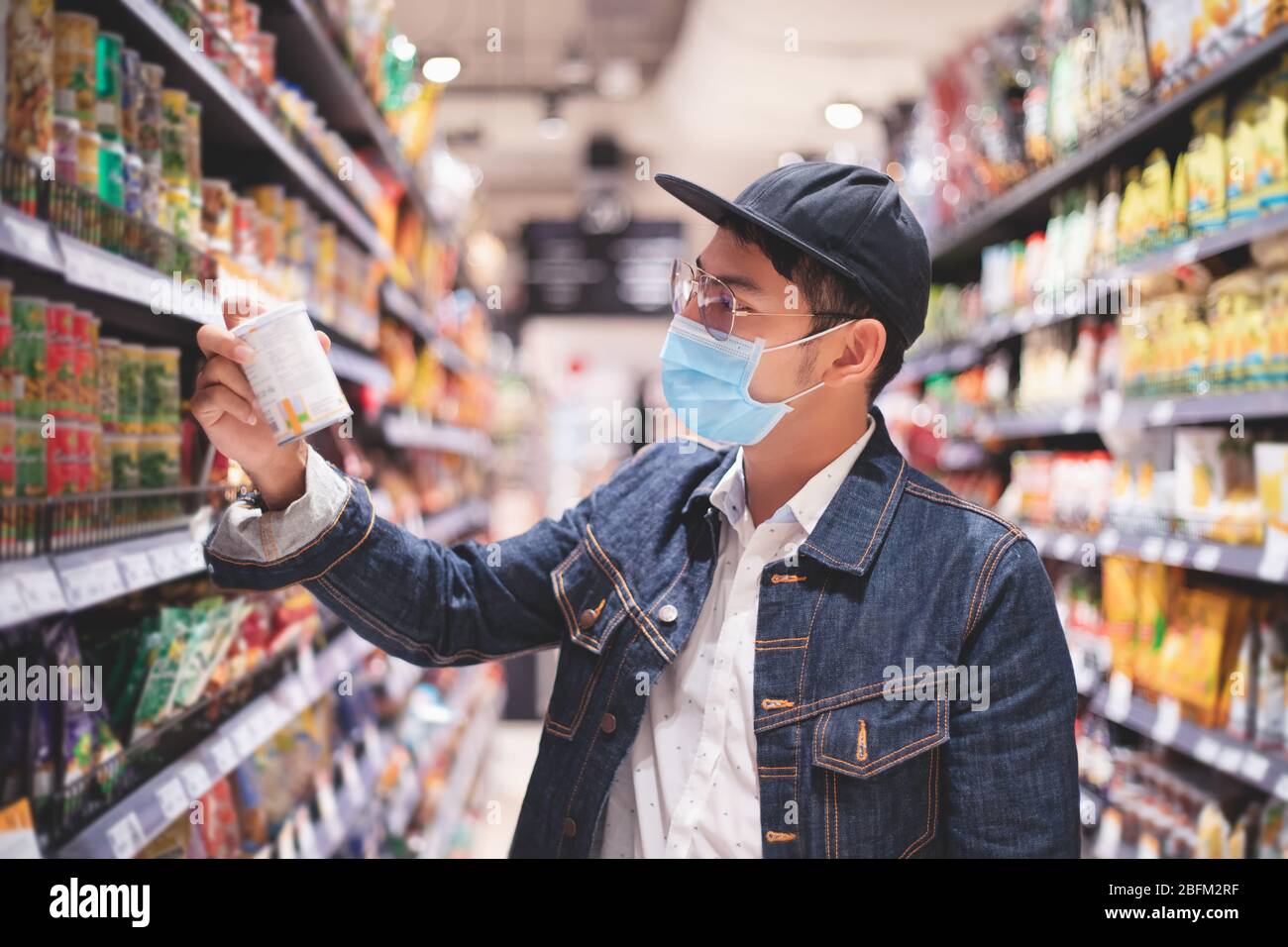 Gli uomini asiatici comprano e acquistano cibo per accovare durante l'epidemia di Covid Foto Stock