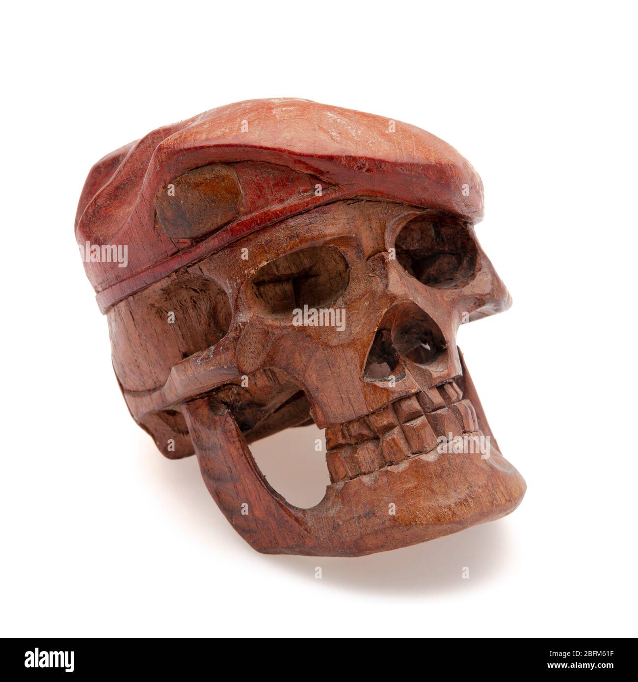 Scultura di un cranio di legno isolato di fronte ad uno sfondo bianco Foto Stock