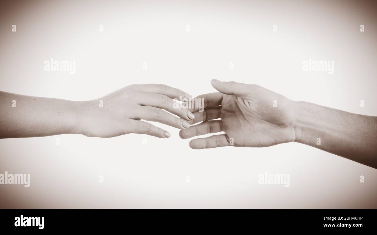 Due mani che si avvicinano l'una all'altra. Concetto di aiuto. Tonalità vintage Foto Stock